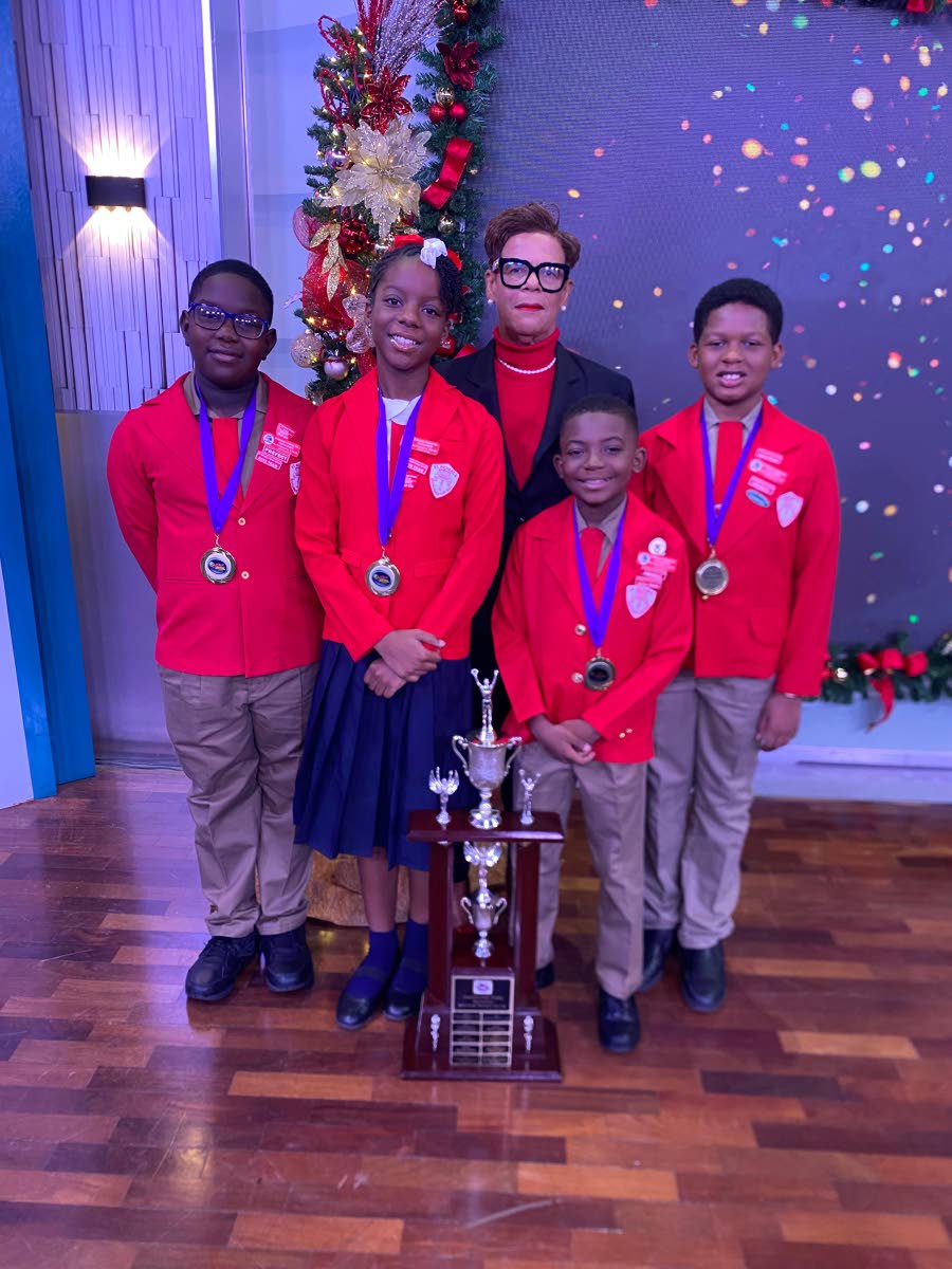 Mantock (centre) returned to voluntarily coach St Richard’s Primary to the championship title of the Junior Schools’ Challenge Quiz competition. The veteran educator appeared with the winning student team (from left): Jomar Danvers, Gabrielle Brown, Ad