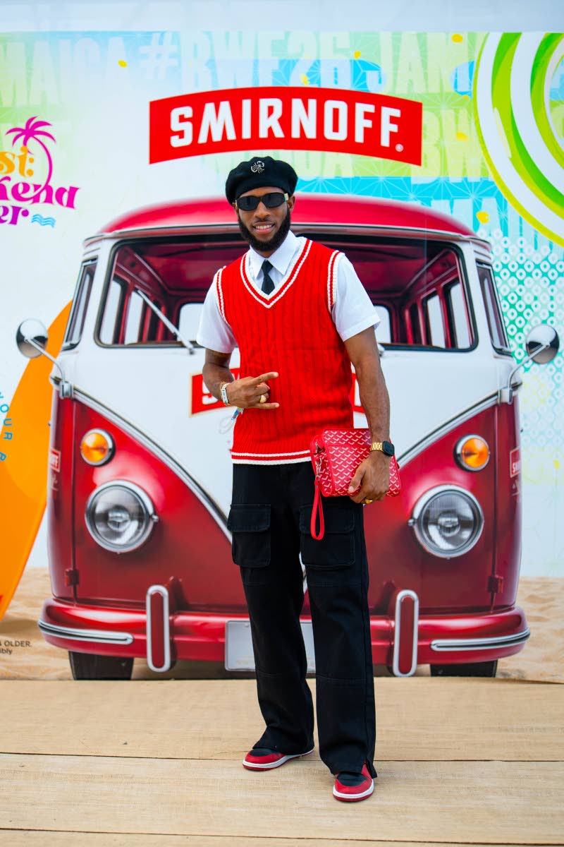 Chef Oniel Ingram layers a red V-neck sweater vest over his look, pairing it with black trousers, shades and a black beret.