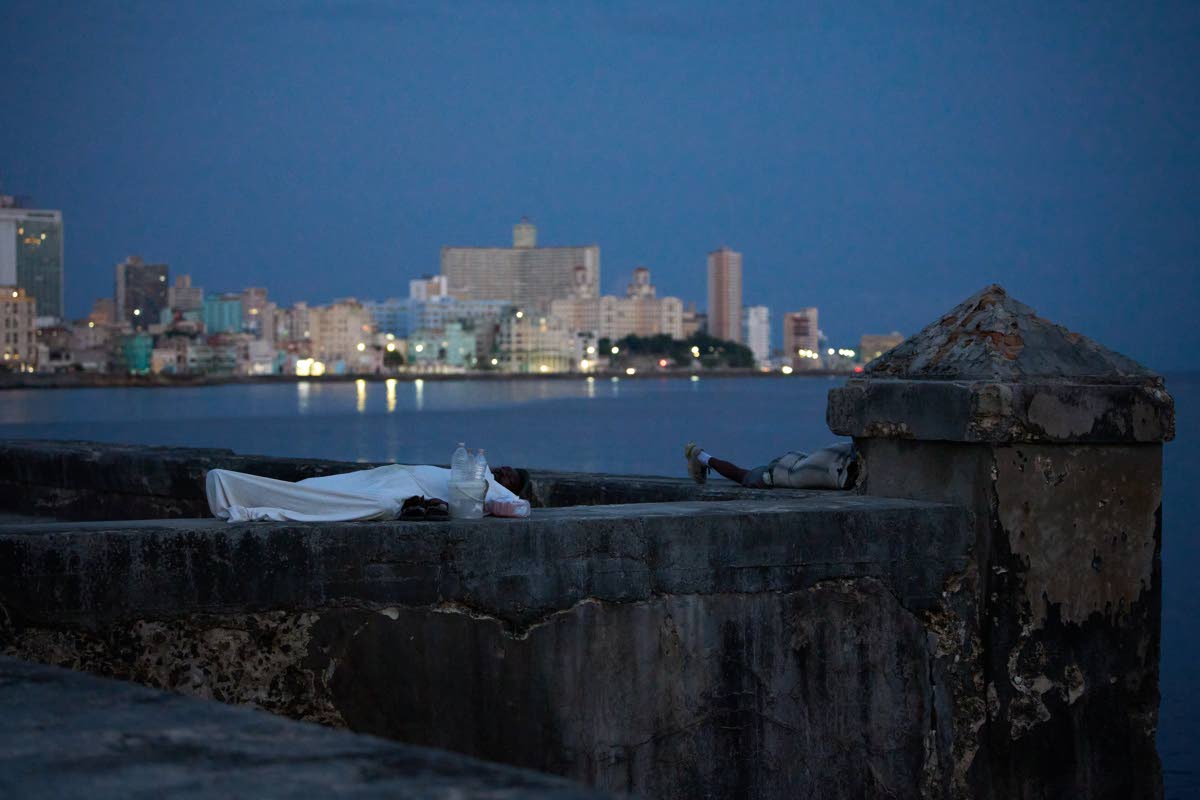 People sleep on the Malecón seawall to escape the heat of their homes during a power outage in Havana, Cuba.