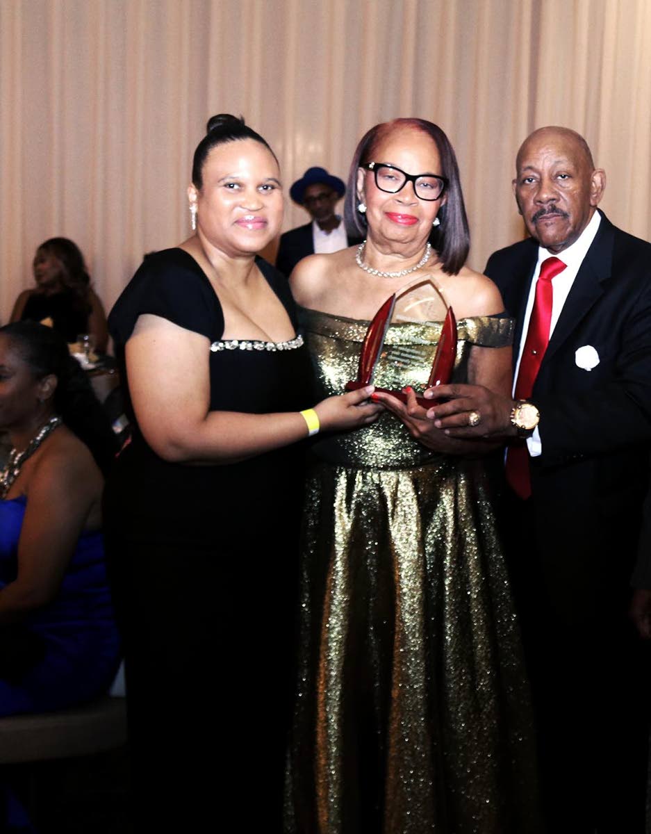 Chargé d’Affaires ad interim at the Embassy of Jamaica in Washington, DC, Lishann Salmon (left), and JAM President and CEO Ricardo ‘Rick’ Nugent (right) present the Marcus Garvey Award to Claire Robinson, manager and director of Clear Sky Travel and