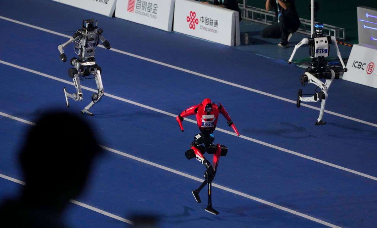 Robots compete in the 100m race during the opening ceremony of the World Humanoid Robot Games in Beijing, Saturday, Aug. 22, 2026. (AP Photo/Achmad Ibrahim)