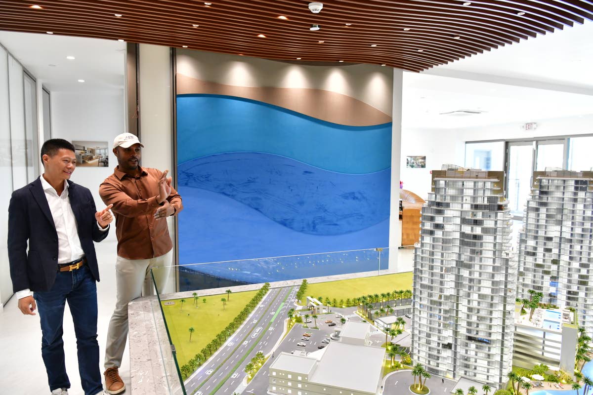 Yangsen Li (left), chief executive officer of LCH Development and developer of The Pinnacle, in conversation with Miller as the two look at a scale model of the luxury residences under construction.