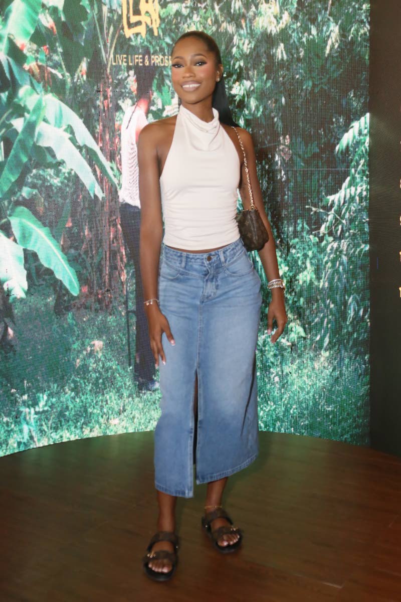 Dancehall artiste Elle Jhenaé strikes a pose in a white halter top paired with a denim midi skirt.