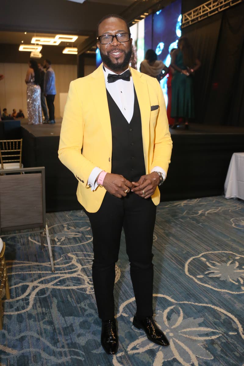Adrian Atkinson, voice and speech trainer for the Miss Universe Jamaica Organisation, adds a pop of colour to his classic black-and-white suit.
