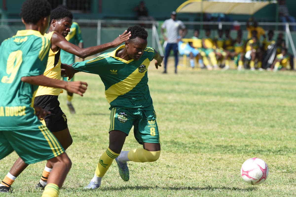 Nichwayne Patrick (right) from Excelsior High School and Jerome McCarthy (centre) from Kingston Technical High compete for the ball during their Ali Cup football match played at Excelsior High School last Thursday.