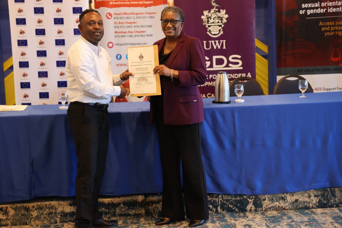 Conrad Saunders, programme coordinator at the Ministry of Labour and Social Security, receives a certificate from Dr Jennifer Brown-Tomlinson, medical director, Jamaica AIDS Support for Life.