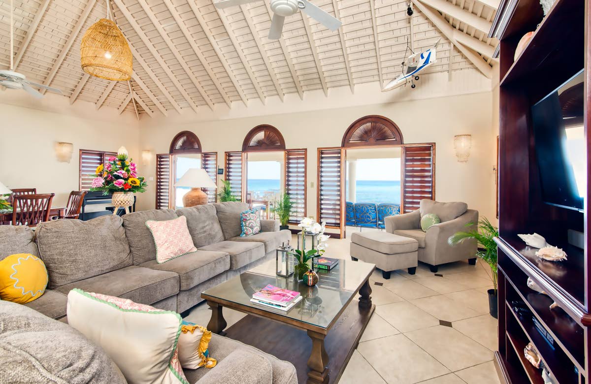 The living-dining room flows seamlessly into the seascape beyond.