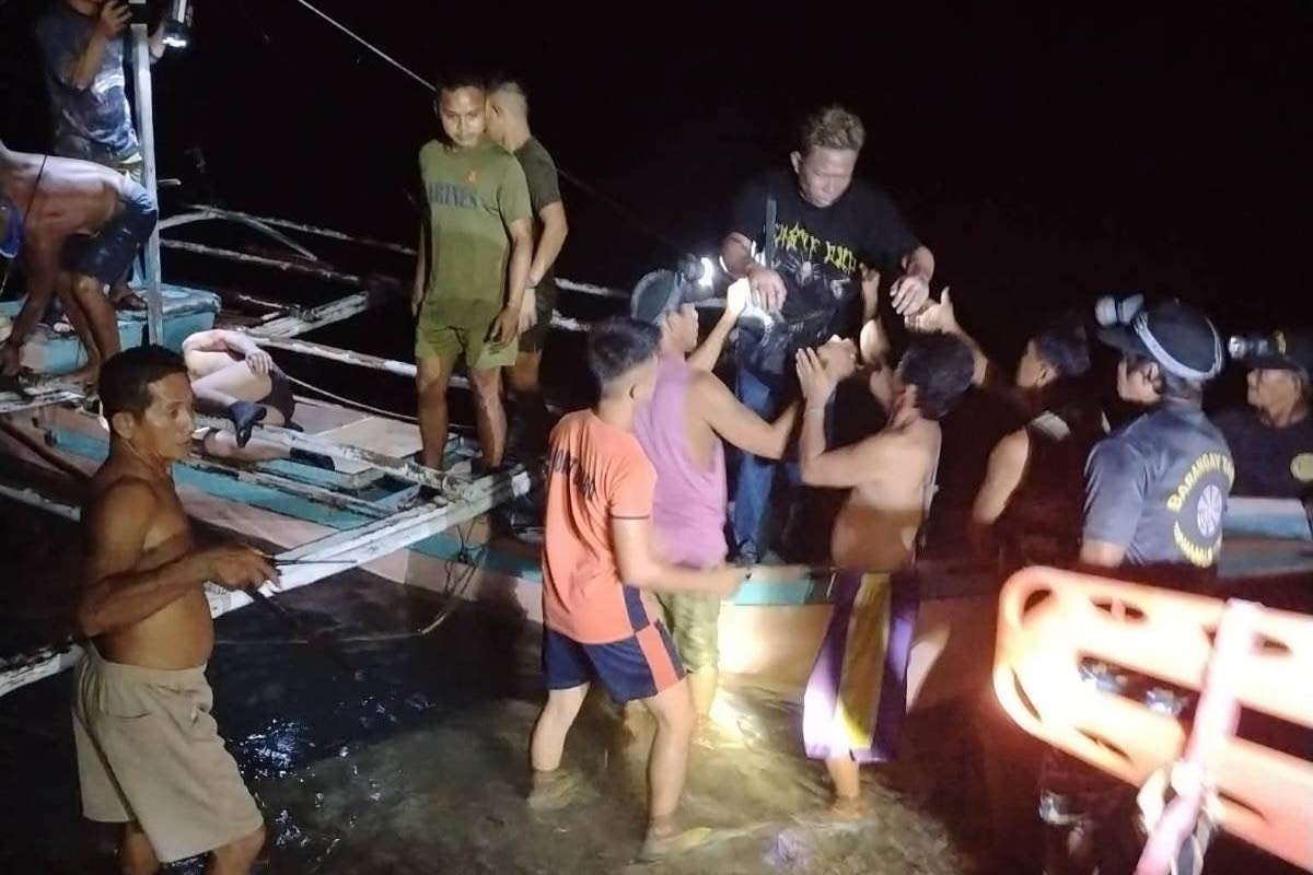 In this image provided by the Philippine Coast Guard, a survivor is assisted as he alights from a small boat after being rescued from a burning ferry off Palawan province, Philippines on Wednesday Sept. 9, 2026. (Philippine Coast Guard via AP)