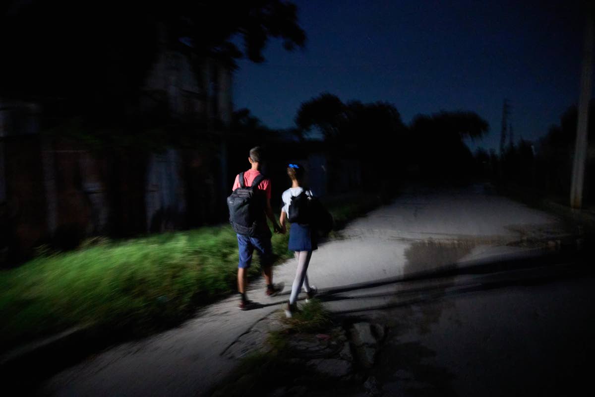 Ballet student Roxana Perez de la Mora, right, walks with her brother Rodrigo during a blackout on their way to the National Ballet School in Havana, Cuba, before sunrise, September 16.