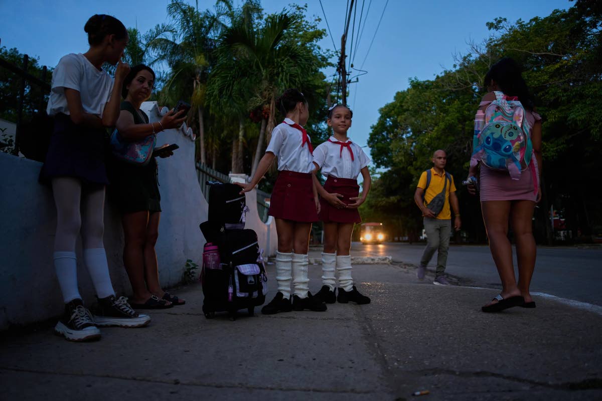 Ballet students practise ballet positions while waiting for transportation to get to ballet school in Havana, Cuba, at sunrise, September 16.