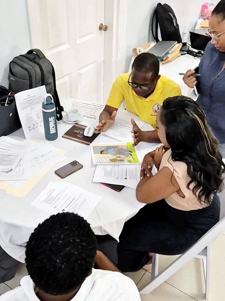 ECC officers work with Irie Homes Toolbox materials during the five-day training, gaining hands-on experience with the tools they will use to support parents and caregivers.