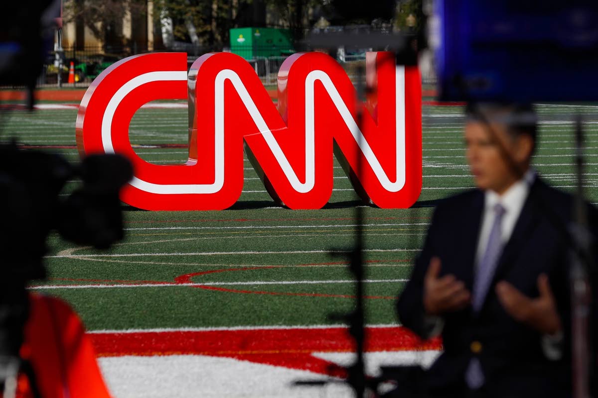 A journalist records a video near a CNN sign on an athletic field outside the Clements Recreation Centre, where CNN/New York Times hosted the Democratic presidential primary debate at Otterbein University, Monday October 14, 2019 in Ohio, USA. 