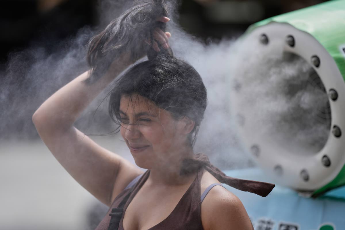 A person cools off at a cooling mist spot on a hot and sunny day at the Sensoji Buddhist temple in Tokyo’s Asakusa district on Aug. 7, 2026.
