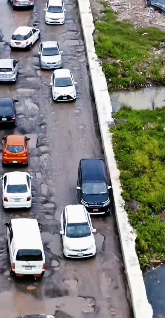 Motorists navigating the pothole-riddled Seaview Drive in Lucea recently.