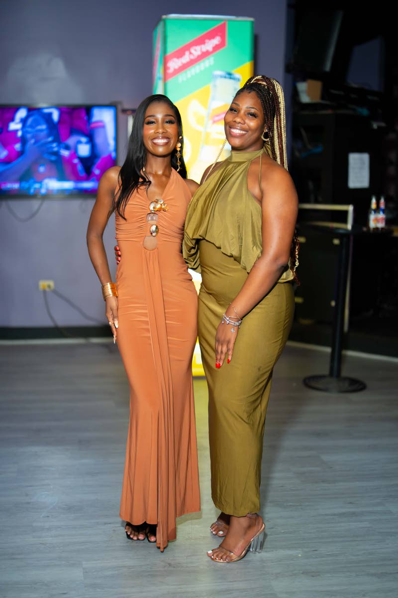 Cast member of the digital series Kimmoy ‘Kim’ Shirley (left) shows off her earth-toned halter gown with keyhole metallic accents from Fashion Nova, posing alongside realtor Oshiene Brown, who sports an olive green draped-neck dress from Coco Boutique.