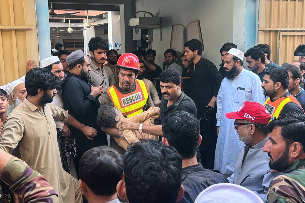 A rescue worker carries an injured child after rescuing him from the rubble of a roof collapse at a private school, in Peshawar, Pakistan, Thursday, Oct. 15, 2026. (AP Photo/Arif Khan)