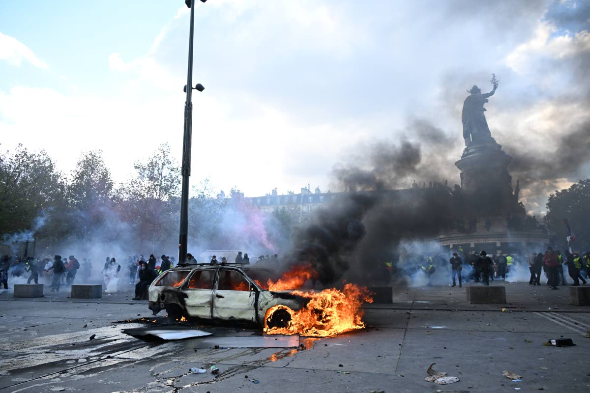 A car burns at Place de La Republique during a protest against rising living costs in Paris, Saturday, Oct. 17, 2026. (AP Photo/Emma Da Silva)