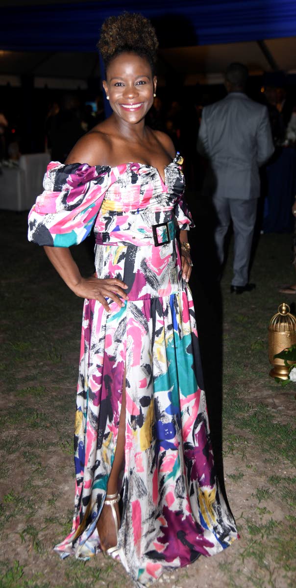 Celebrating her aunt, Dr Joy Spence, 
Dr Monique Spence-Watson embraces the evening’s cocktail attire in an off-the-shoulder maxi dress.