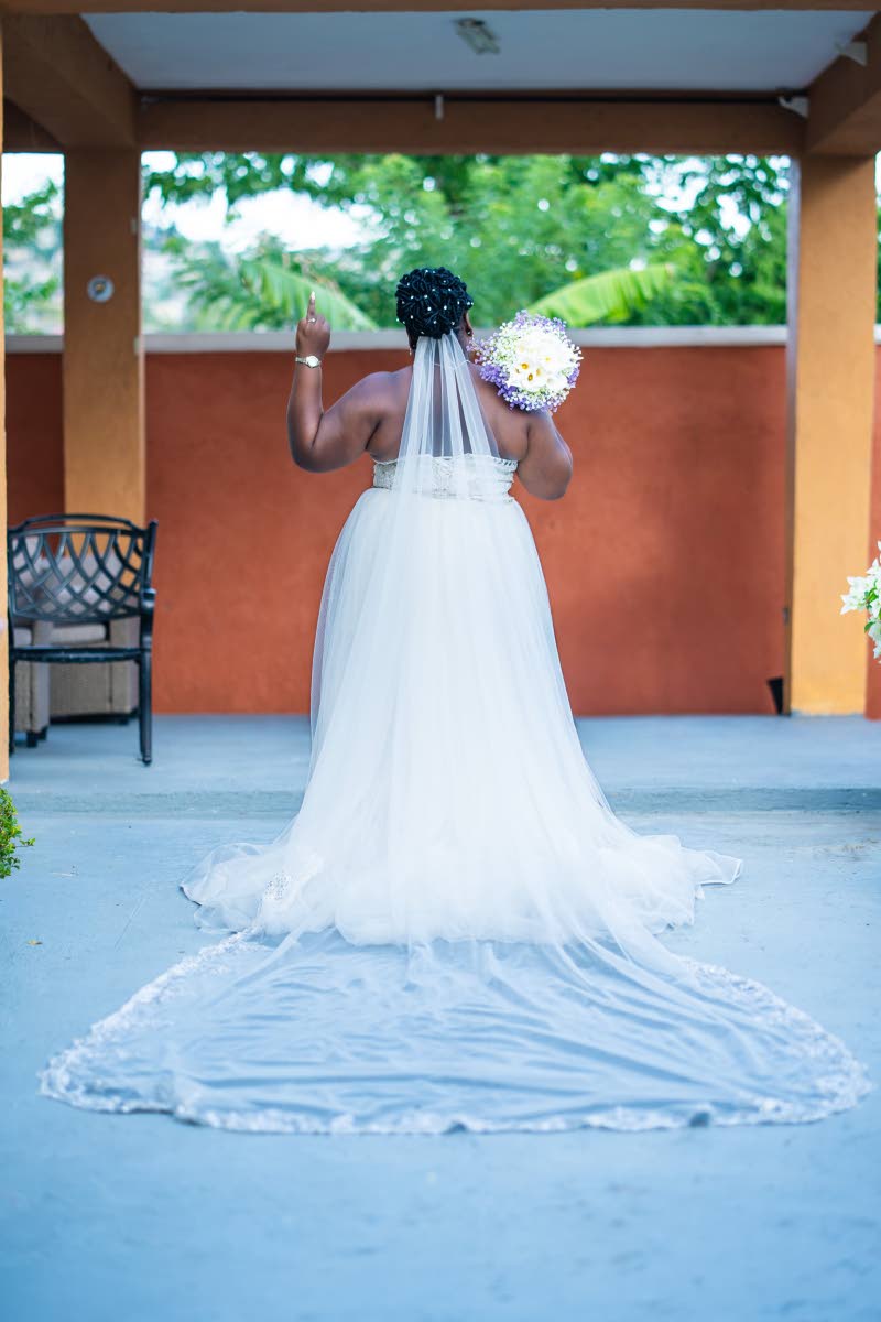 Left: With her ring finger in the air to show off her diamonds, Throyann strikes an iconic bridal pose, showcasing the back of her wedding dress.