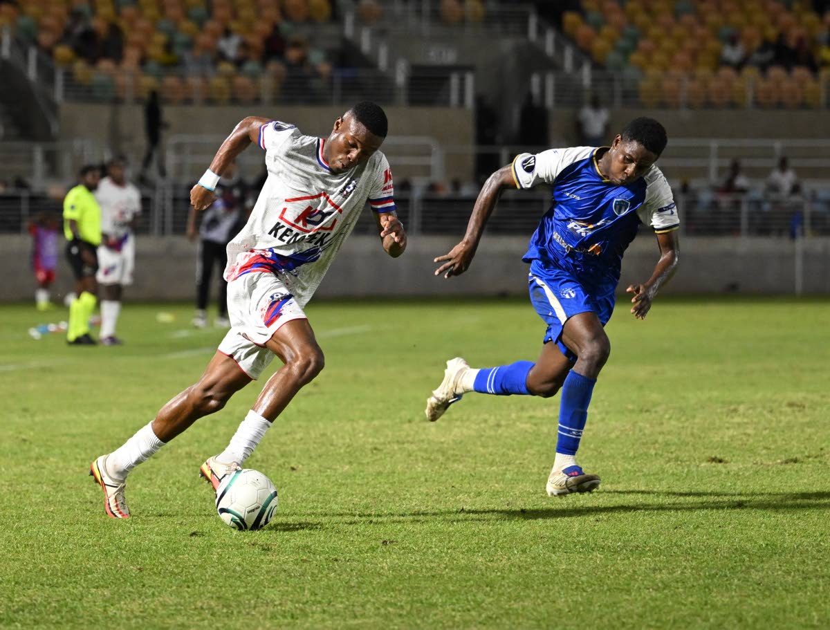 Portmore United’s Jevaughn Grant (left) dribbles by Violette AC defender Fernando Ciceron during their Concacaf Caribbean Cup second-leg semi-final at Sabina Park last night. 