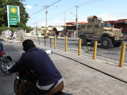 Residents watch a Kenyan police armoured vehicle patrolling in Port-au-Prince, Haiti, on September 2.