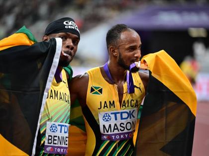 Tyler Mason (right) and Orlando Bennett celebrate the respective bronze and silver medals they earned from the men’s 110-metre final at the World Athletics Championships inside the Japan National Stadium yesterday in Tokyo. 