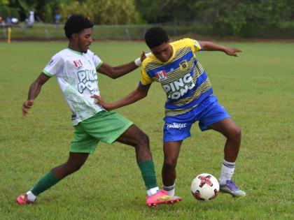 Rusea’s High School goalscorer Maliek Headed (right) tries to evade the tackle by Frome Technical High School’s Jevani Plummer during their ISSA daCosta Cup match at the Colin Miller Sports Complex on Tuesday. Rusea’s won 3-1 after the second half of