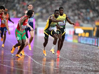 Jamaica’s Jashauna Dennis (right) hands over to Rusheen McDonald (second right) during the men’s 4x400-metre final at the World Athletics Championships in Tokyo, Japan, yesterday.  Jamaica finished seventh in 3:03.46.