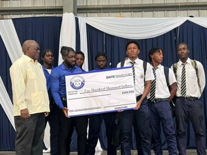 
From left: Jamaica College principal, Wayne Robinson, helps Manning Cup players Joshua King, Devonte Allen, Dontae Logan (captain holding cheque), Duwayne Burgher, Delajahe McCormack and Domanic Clarke (also holding cheque), and David Simmonds display a s