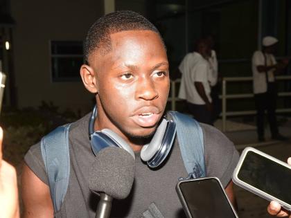 Oblique Seville talks with members of the media on his arrival at the Norman Manley International Airport from the Tokyo World Athletics Championships where he won gold in the men's 100 metres.