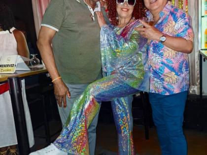 DJ Stokey Love from Kool FM (left) and Brian Ribbi Chung, co- director Ribbiz Ultra Lounge, celebrate with Judith Grant after she won the prize for best dressed at the Groovy 70s 80s Edition of Big People Sundays at Ribbiz on Ardenne Road recently.