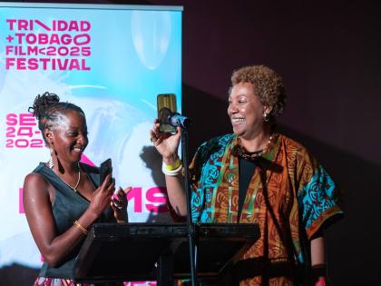 Alison Duke (right), film director, holds the phone to the microphone as Sister Nancy addresses the audience at the gala screening of the documentary on her life. Sharing in the moment is Ngardy Conteh George, producer and co-owner of OYA Media Group. 