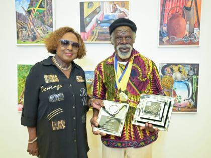 Minister of Culture, Gender, Entertainment and Sport Olivia Grange (left) and Most Outstanding Overall Artist, Nugent Hewitt, 72, who received six gold medals and one silver medal in the 2025 Jamaica Cultural Development Commission Visual Arts Competition.