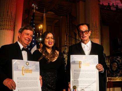 Jason Henzell (left) and Josef Bogdanovich receive their citations from Tiffany Raspberry, deputy mayor for intergovernmental affairs in New York. 
