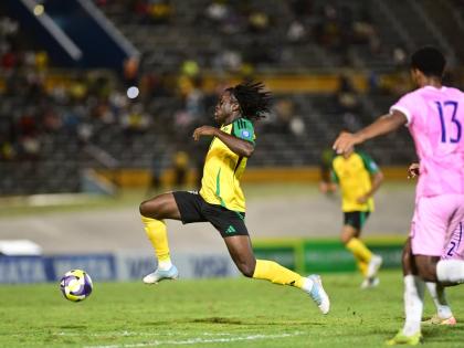 Jamaica's Tyreece Campbell (left) drives past Bermuda's Keziah Martin during their Group B Concacaf World Cup qualification football game at the National Stadium earlier tonight. Jamaica won the game 4-0.