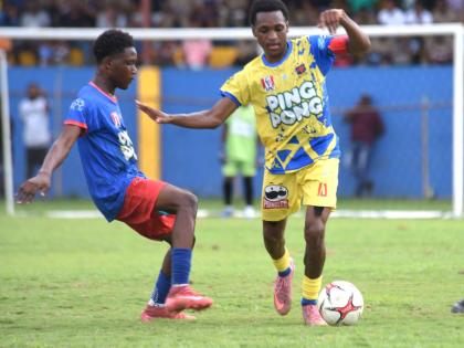 St Elizabeth Technical High School’s (STETHS) Deandre Barnett (right) tries to evade the challenge of Kemps Hill High School’s Rcardo Dea during their ISSA daCosta Cup round-of-16-clash at the STETHS Sports Complex yesterday.