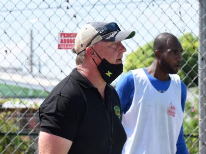 National basketball team head coach Rick Turner (left) gives instructions to members of  the national team during a training session at the Stadium Courts.