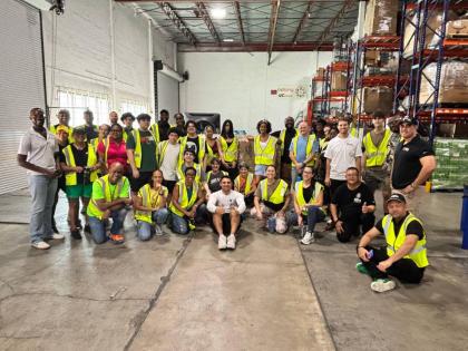 Marlon Hill, Lead Volunteer, Caribbean Strong, (left stooping), poses with the GEM team. 
