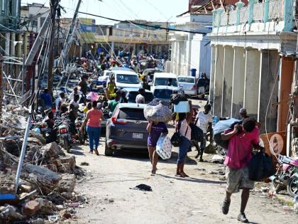 Persons travelling with supplies along Crane Road in Black River St Elizabeth, after Hurricane Melissa.