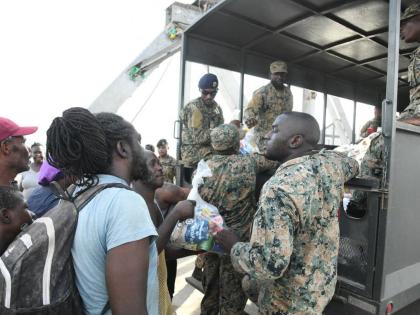 Members of the Jamaica Defence Force hand out care packages to residents of Crane Road in St Elizabeth. 