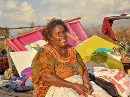 Nicola Gowdie sits in tears among the remains of her house on Crane Road, St Elizabeth, on October 30.