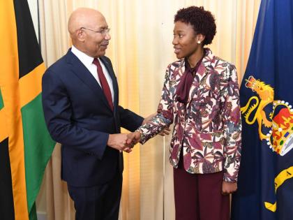 Governor General Sir Patrick Allen (left) congratulates Tiana Dinham after she was named the 2026 Rhodes Scholar on Thursday.