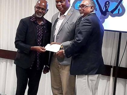 Irwine Clare Sr (left), founder and CEO of Team Jamaica Bickle, presents hurricane relief cheque to GC Foster College of Physical Education and Sport  Principal Maurice  Wilson (centre) and Board Chairman  Vishu Tolan.
