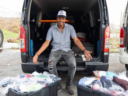 Beaming with gratitude, JPS’s Kenroy Williams displays donated clothing items that formed part of his community relief drive across Westmoreland, Hanover, and St James. Through partnerships with local businesses, individuals, and overseas supporters, Wil