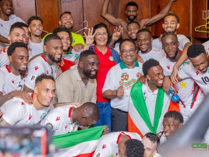 President of Suriname Jenny Simons and Vice-President Gregory Rusland (centre) celebrate with the Natio players in the locker room after their victory over El Salvador on Thursday.