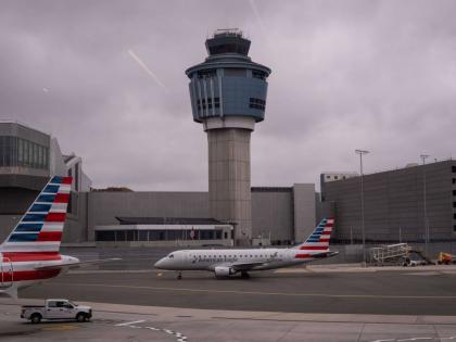 An American Eagle plane moves past the FAA Air Traffic Control tower at LaGuardia Airport (LGA) in the Queens borough of New York, Sunday, November 9, 2025. (AP Photo/Adam Gray)