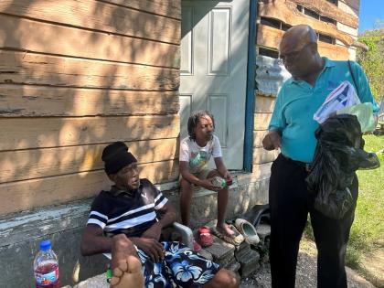 Gerald Miller  (right), health promotion and education officer for Westmoreland, educating residents on the risks of contracting leptospirosis and other diseases from the nearby Ancho River.