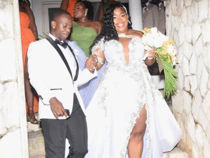 Jevaughn leads his wife, Jordine, down the stairs of their wedding venue.