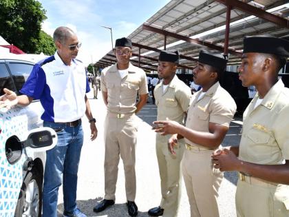 Richard Gordon (left), manager of business development at JPS, engages Caribbean Maritime University students on the Charge ‘n Go network and the advantages of electric mobility.