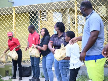 Digicel representatives are joined by a student and parent in offloading relief packages to benefit parents of special needs students at the Catherine Hall Primary School. The handover took place at the Catherine Hall Primary School’s Special Education U